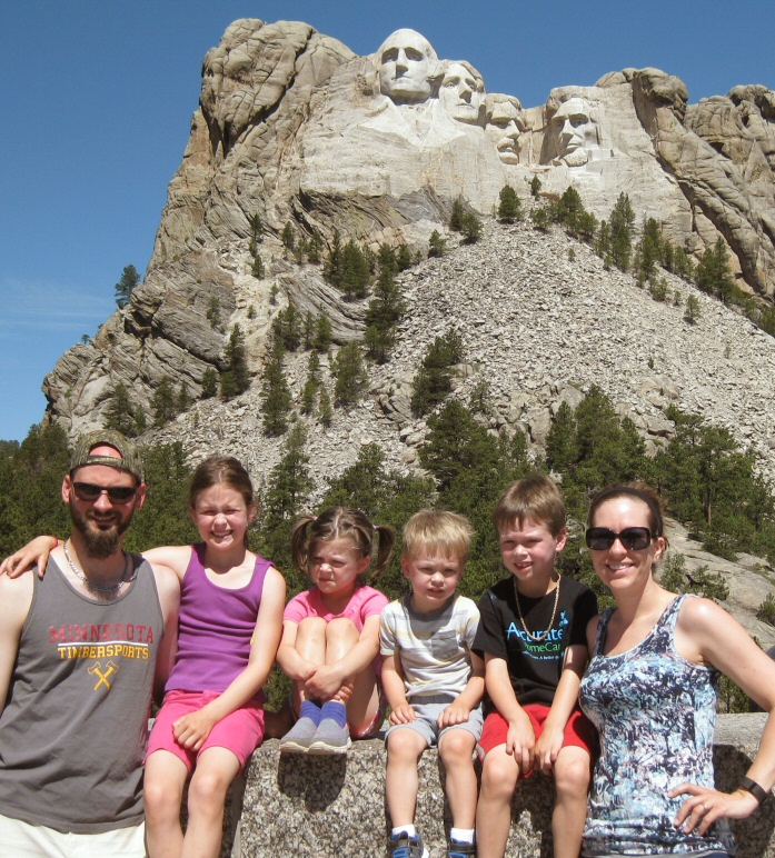 The whole family (less the baby), squinting for the camera at Mt. Rushmore. It was in the upper 90s by noon.